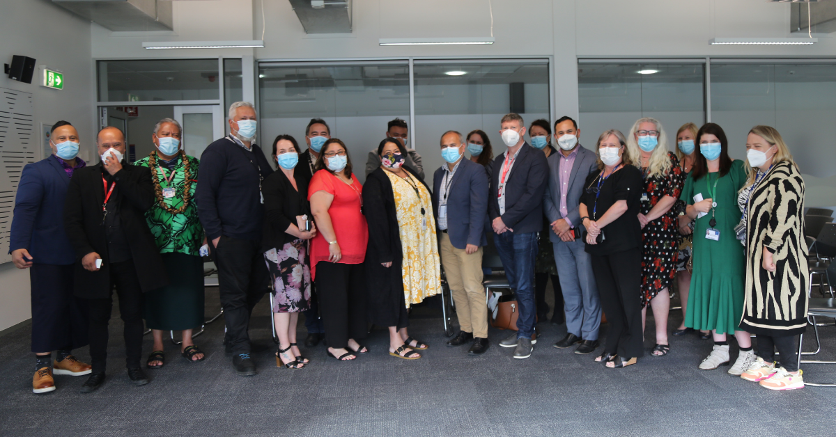 Group of people wearing masks for COVID-19 standing together in a large room